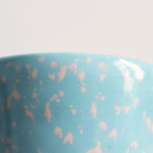 Detalle de la textura de manchas rosas sobre fondo azul del bol artesanal tache